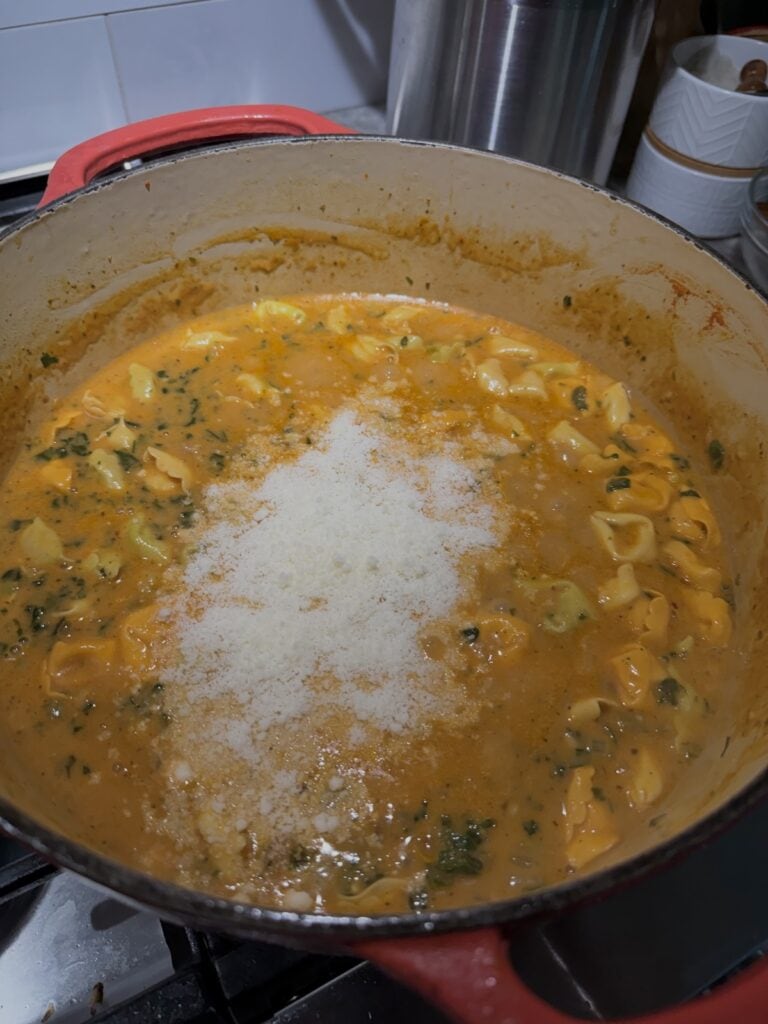 Grated cheese just added to pot to finalize the Creamy Sausage and Tortellini Soup.