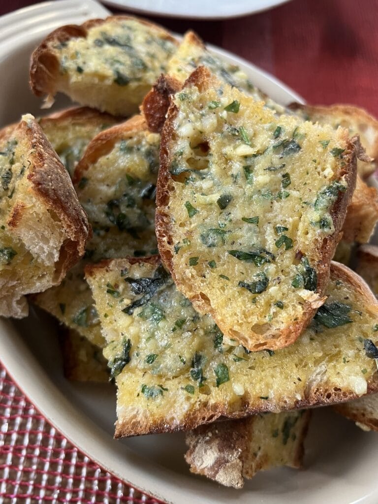 Broiled garlic bread sliced in bowl.