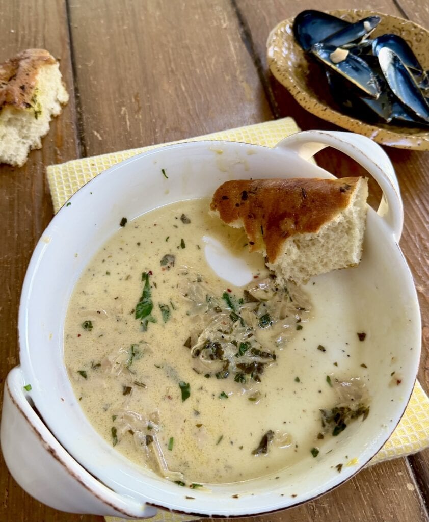Bread in dish with remaining creamy white wine sauce.