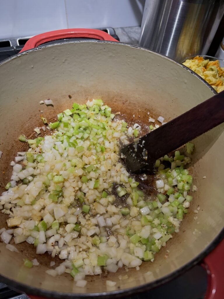 Sautéing aromatics (onions, celery, garlic) in Dutch oven.