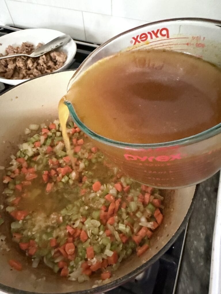 Pouring broth into the pot.
